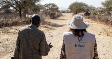 Concern staff member and representative from Irish Embassy to Sudan walk down a sandy road in Sira, Chad