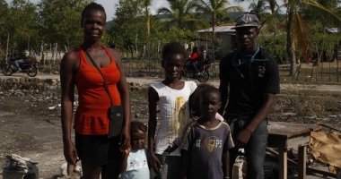 The François family, standing among the rubble of what used to be their home. They evacuated during the hurricane in 2016. Photo: Kristin Myers/Concern Worldwide