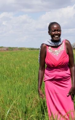 A farmer stands in front of her rice farm in northern Kenya. 