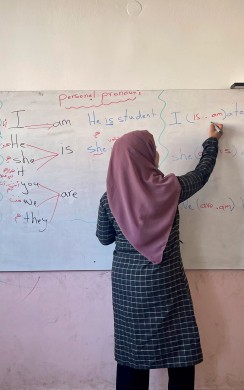 Teacher writing on blackboard