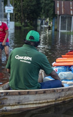 Concern Emergency Response team member distributing response materials by boat in Noakhali district