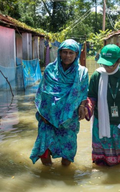 A Concern team member walks with a flood affected woman 