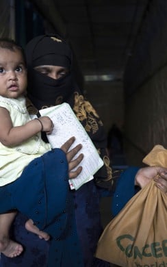 Dina* with her one-year-old child Barsha*, just received Super Cereal Plus, a fortified blend of wheat and soya, rich in protein and nutrients provided to pregnant and breastfeeding mothers at the Rohingya camp through the Integrated Nutrition Facilities (INFs) in the camps. (Photo: Saikat Mojumder/Concern Worldwide)