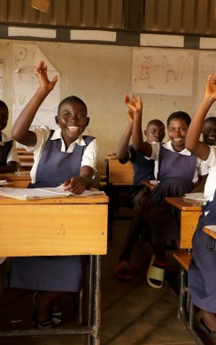 Students in Malawi classroom raising their hands