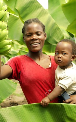 Suzgyo Daveson (35) with Medson (1) hold bananas in Kasanya Village