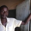 Man in Malawi standing in front of a classroom