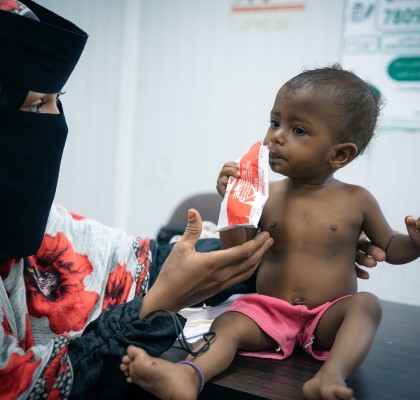 Aalia* (15 months) with her mother, eating nutrition supplements provided at a Concern supported health clinic in one of the displacement camps in Yemen, where Aalia is receiving treatment for malnutrition and showing steady progress. Photo: Ammar Khalaf/Concern Worldwide