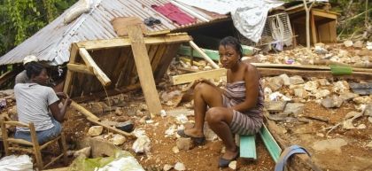 A resident of Camp-Perrin sits outside her house which was destroyed by the 7.2 magnitude earthquake in Haiti.