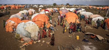 Orange and white makeshift tents surrounded by children in Somalian IDP settlement