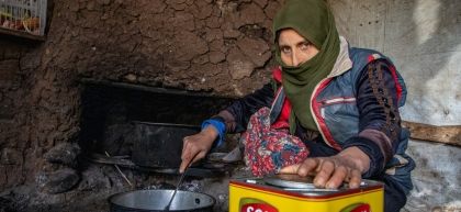 Fatima cooking vegetables in small room
