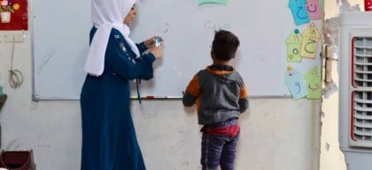 Hani (name changed) writing on blackboard in school