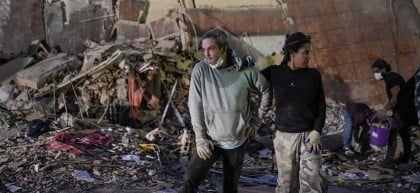 People stand at the site of a collapsed building following an earthquake in Caracas on June 25, 2026