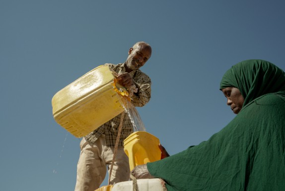 Man pouring water into a jug