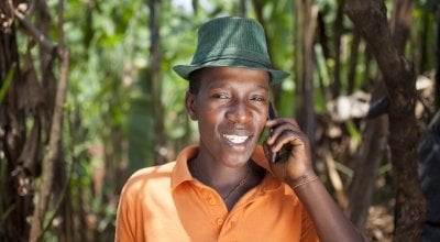 Olivier Irankunda (23) uses his mobile phone at his home in Mabayi, Cibitoke. Photo: Abbie Trayler-Smith / Concern Worldwide.