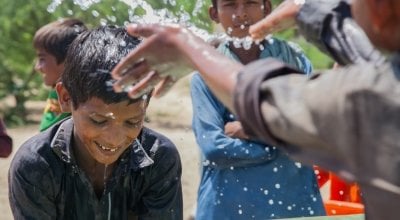 Somro and Kishore from Satla Bheel village are playing with water at the newly installed plant system.  Thar Desert, Pakistan. Phot: Black Box Sounds / Concern Worldwide.s