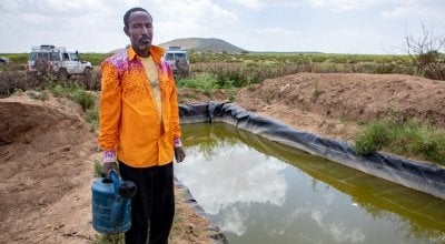 A lead farmer stands by his water catchment system in North Somaliland. As part of the climate change adaptation work, Concern provided him with a tarpaulin to which he has sank into a hole to store as much water as he can for his crops during the dry season. 