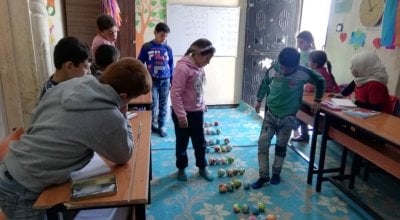 Children enrolled in the non-formal education (NFE) programme in the 'Make Math Fun' class in Northern Syria, January 2020. This is part of the numeracy sessions to learn multiplication using small coloured balls.