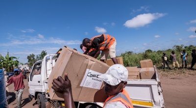 Workers unload kitchen kits from a truck at a distribution in Ndeja, Mozambique, which was hard hit by cyclone Idai in March 2019. Photo: Tommy Trenchard / Concern Worldwide.