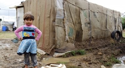 A refugee child stands in front of her home in an informal tented settlement in Akkar district.
