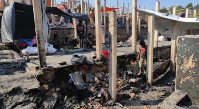 Rohingya refugees search among the ruins of burnt shelters at the camp at Cox's Bazaar.