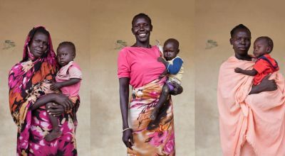 South Sudanese women wearing various shades of pink and holding their infants