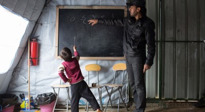 Syrian refugee boy studying in an informal classroom