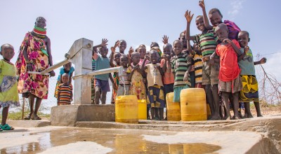 Regina Ekiru (30) and some children from Kadak Aikeny village, Turkana, Kenya at a well that Concern rehabilitated. May 2022. Photo: Gavin Douglas/Concern Worldwide.