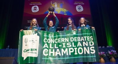 Concern debates champion team holding sign and trophy