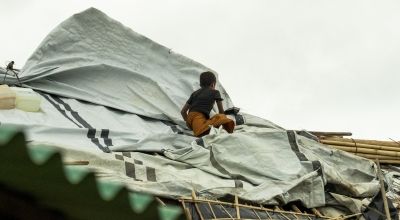 A child protects his shelter after Cyclone Mocha hit Camp 13, Ukhiya, Cox’s Bazar