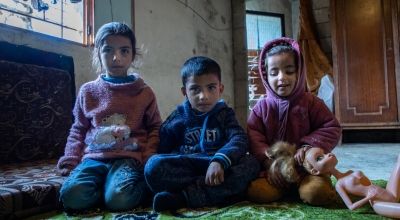 Khaled and Maram's children sit on floor of the building they live in