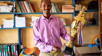 Mr. Boru Ali holds up a trophy won by his students from Bubisa Junior Secondary School at the 2023 Science Fair in Marsabit County. Photo: Eugene Ikua/Concern Worldwide