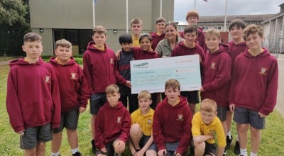 Class from Scoil Assaim BNS Raheny holding cheque for money raised for Concern