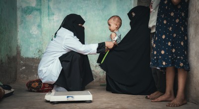 Rima* with her mother and Nabilah Mohammed, the Community Health Volunteer (CHV). Rima received treatment for malnutrition in a health center supported by Concern in Al-Shaqa’a village, Tuban district. Photo: Ammar Khalaf/Concern Worldwide