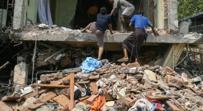 People climb into a damaged building as they look for survivors in Mandalay on March 29, 2025, a day after an earthquake struck central Myanmar. 