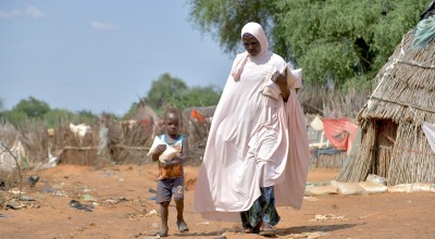 Baria Moumouni carries home packages of fortified flour with her child, distributed by Concern in Tanawara village, Niger. Photo: Concern Worldwide