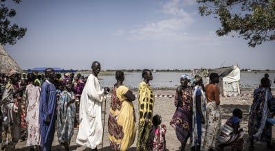 Nyepahan Ketket (in blue and yellow dress) is registered and given money in a cash distribution in Chotyiel, a settlement surrounded by flood water near Gwit, south of Bentiu in Unity State. Photo: Ed Ram/Concern Worldwide
