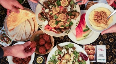  Dinner part scene shown from above. People share Palestinian food. 