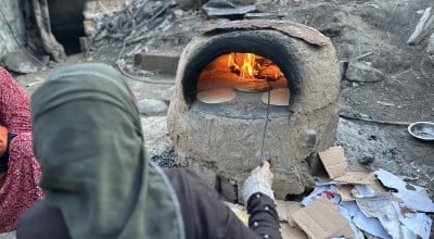 Manila* and her family were displaced to Rafah then to Al-Nuseirat in Gaza. She makes some bread with the resources they have, but they have no tent or access to food and water. (Photo: Khalil Adwan)