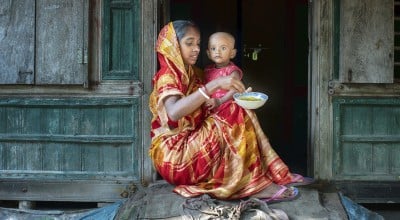 Mitali Mondal is feeding nutritious food to her eighteen months old daughter, Mahi. Every month mothers of the Haldi Bunia community get together once, arrange nutritious meals for their small kids, and feed them together. This session helped mothers to teach each other nutritious meals for their growing children. Several mothers get together and support with the cooking steps. The mother group receives ingredients from the Collective Responsibility, Action, and Accountability for Improved Nutrition (CRAAIN