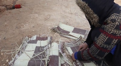 Samira* tears up a worn out-mat to burn amid the harsh winter in Syria