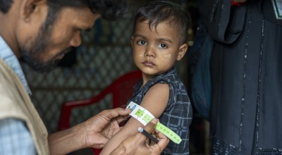 Zamal getting his upper arm measured by a community health worker