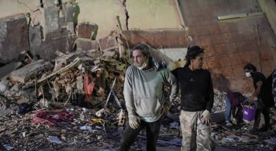 People stand at the site of a collapsed building following an earthquake in Caracas on June 25, 2026