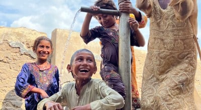 Children are bathing in the water of a village hand pump to cool down during the heatwave. Photo: Arif Shad/Concern Worldwide.