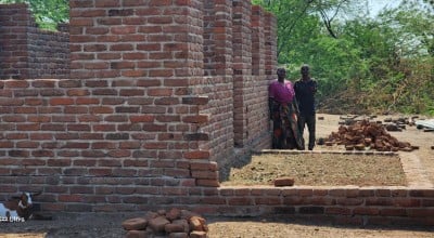 John and his wife Mary standing in front of their resilient house under construction. Photo: Concern Worldwide.