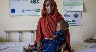 Faizah holding her daughter Malliya in health centre 