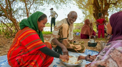 Concern Communications Officer Kalkidan Jabir shares a meal with Hussein Abdulahi Hussein and his wife Nadifa Yusuf and their family in Alloley Kebele, Dollo Bay District in the Somali Region of Ethiopia. Hussein leads a group of 45 farmers who are part of an agriculture group supported by the Hannano Programme. With this support, they received improved variety of seeds, a generator, fuel, water pumps, and training.