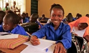 Young girl smiling at her desk in school