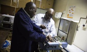 Shadrack Wamwayi and Steve Belle, biomedical engineers working on equipment at the Kenyatta National Hospital, Nairobi, Kenya, 2014. Photo: by Crystal Wells / Concern Worldwide.
