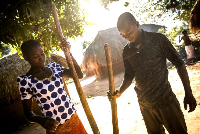Congolese woman and man preparing cassava flour together