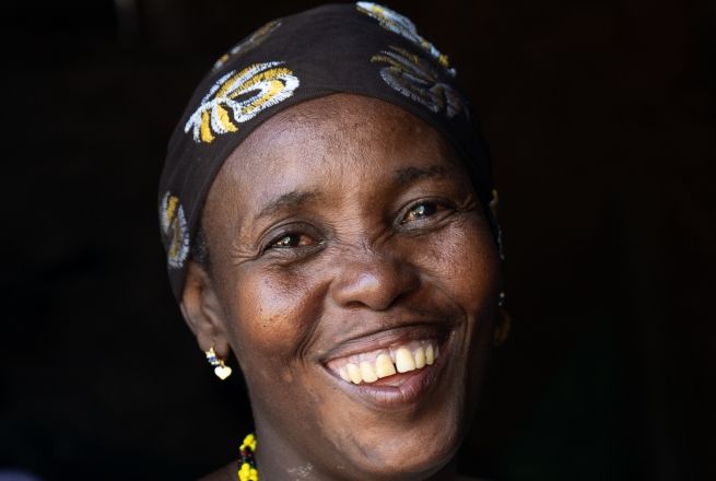 Mwanajuma Ghamaharo, wearing black and yellow patterned headscarf and smiling at camera